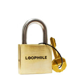 The LoopHole puzzle lock standing upright with its brass key attached by a black cord, made from heavy brass and stainless steel.