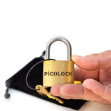 A hand holding the 40mm wide PicoLock to demonstrate its portable size. An engaging, high-value pocket challenge designed to get people off their phones and focused on spatial logic reasoning.