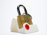 The FunLock beginner trick lock beautifully presented on a sleek white dock stand. An interactive piece of genuine brass craftsmanship that looks great displayed on a study shelf or home workspace.